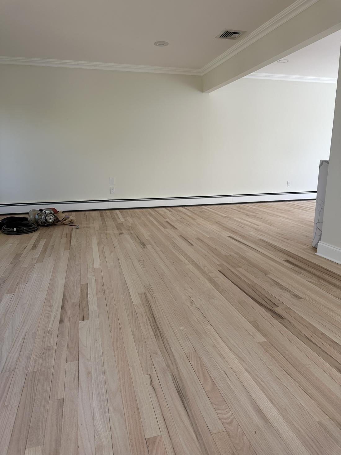 Wide living room floor sanded with drum sander nearby